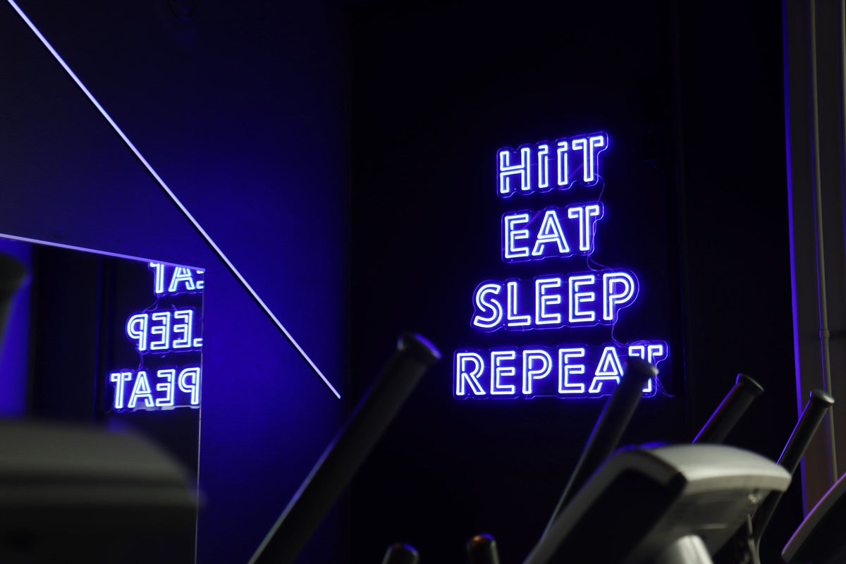 Sinine HIIT EAT SLEEP REPEAT LED-neoonsilt Kuntomaailma jõusaalis Jyväskyläs.
