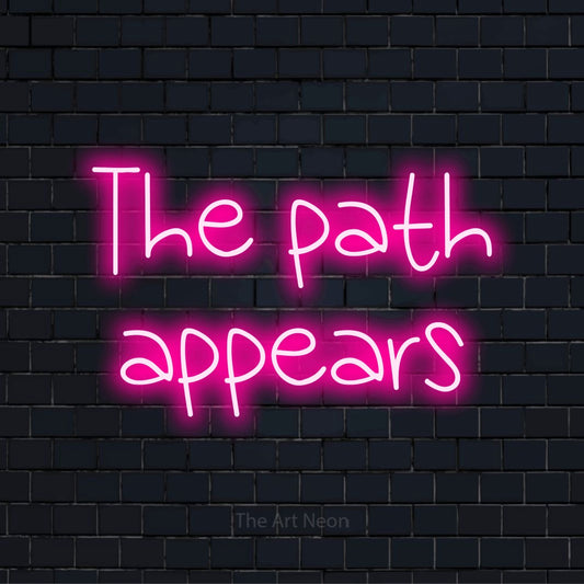 "The Path Appears" script-style LED neon sign on a black brick wall