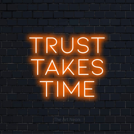 "Trust Takes Time" script-style LED neon sign on a black brick wall