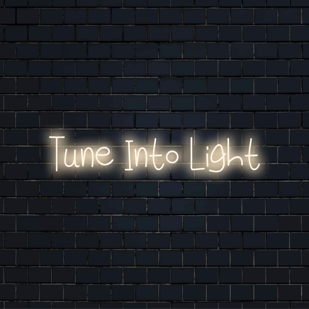 Tune Into Light Neon Light with neon text light against black brick wall