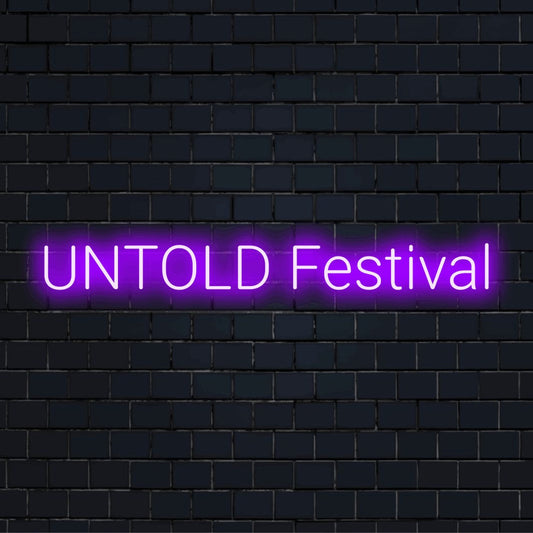 Untold Festival Neon Sign, bright LED glow on black brick background