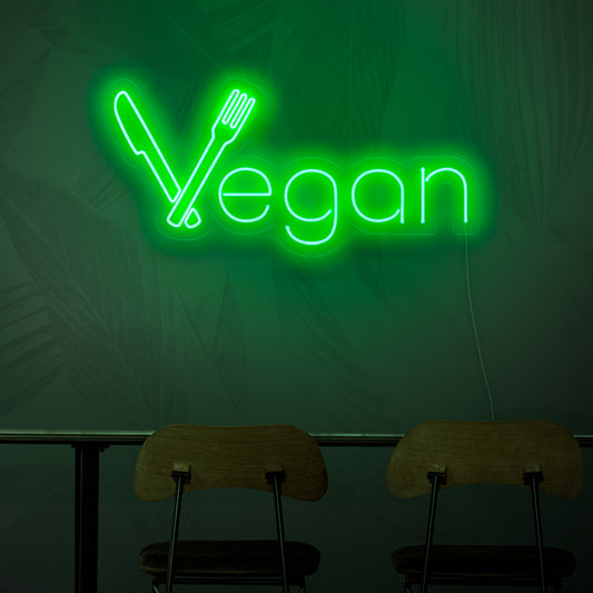 A neon sign that reads 'Vegan', representing the concept of plant-based cuisine with its vibrant green light.