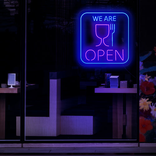 Zadivljujući neonski znak sa simbolima šalice i vilice, koji označava da je restoran ili zalogajnica otvoren. 