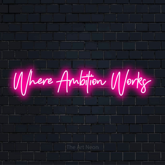 "Where Ambition Works" glowing LED neon sign on a black brick wall